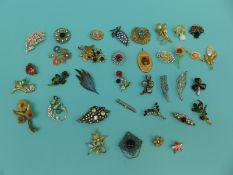 A collection of brooches of largely floral design to include a banded agate 'miracle' example,