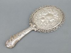 A Victorian hallmarked silver hand mirror with embossed decoration and face to handle,