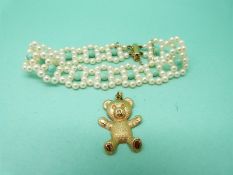 A 9ct gold teddy bear pendant and a pearl and turquoise bracelet with 9ct gold clasp