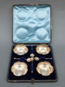 A cased set of four Edward VII hallmarked silver open salts and four spoons,