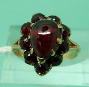 A Victorian ring set with a pear shaped garnet cabochon surrounded by rose cut garnets (size L)