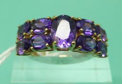 A 9ct gold ring set with oval amethysts (size L)