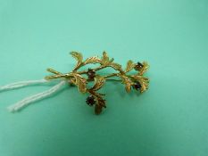 A 9ct gold brooch in a foliate design set with garnets, 5.