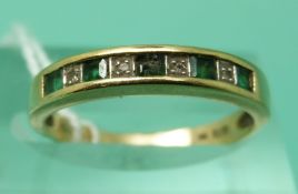 A 9ct gold ring set with alternating emeralds and diamonds (size N)