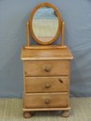 A pine bedside chest of three drawers and a mirror