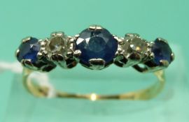 An 18ct gold ring set with three round cut sapphires and two old cut diamonds (size P/Q)