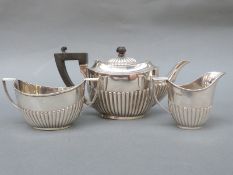 An Edward VII / George V hallmarked silver bachelor's tea set with fluted lower setion,