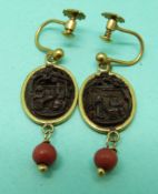A pair of gold plated Chinese Canton earrings set with carved wooden scene and coral drops