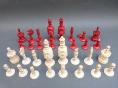 A turned bone chess set, one side stained in red, in wooden box. Height of king 9.