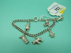 A silver charm bracelet with charms including penguin charm, golf clubs,