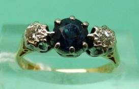 An 18ct gold ring set with a round cut sapphire and two round cut diamonds (size K)