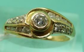 An 18ct gold ring set with a round brilliant cut diamond to the centre and further diamonds to the