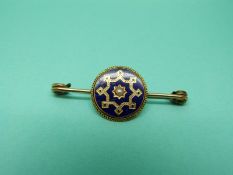 A Victorian brooch set with blue enamel and a pearl to the centre