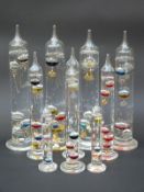 Ten Galileo-style glass thermometers with multicoloured liquids,