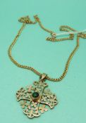 A yellow metal pendant marked 14k in the form of a stylised cross set with a green cabochon on a