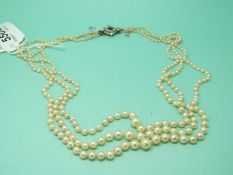 A three strand natural pearl necklace,