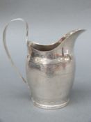 A Georgian hallmarked silver cream jug with engraved decoration marked with Georgian duty mark,
