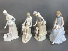 Four Nao figures including boy with lamb, girl with kitten,