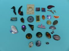 A collection of wooden and enamel brooches including Russian lacquered examples, Ostrich shell,