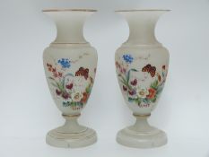 A pair of hand painted pedestal glass vases decorated with butterflies and flowers on opaque ground,