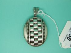 A Victorian white metal locket with raised decoration