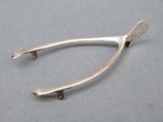 A novelty Victorian hallmarked silver wishbone marked Rd 202071, London 1895 maker Atkin Brothers,