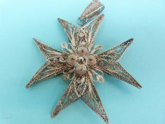 A white metal filigree pendant in the form of a Maltese cross