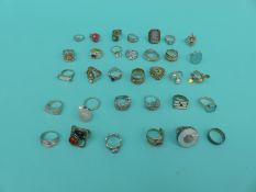 A collection of 33 silver/white metal dress rings including ruby, pearl,