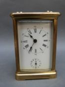 A French corniche cased brass carriage clock with strike and alarm facility and Roman enamel dial