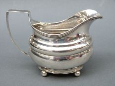 A Georgian hallmarked silver cream jug raised on four ball feet, London 1813, maker William Weston,