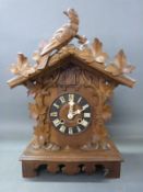 An early 20thC Black Forest two train mantel cuckoo clock striking on a gong with vine leaf and