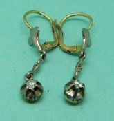 A pair of 18ct gold earrings set with a diamond to each and fleur de lys decoration