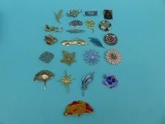 A collection of brooches to include glass, enamel flowers, leaves,