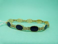 A yellow metal Egyptian bracelet set with lapis lazuli oval panels (26.
