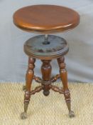 An adjustable work or music stool with glass ball and gilt claw feet marked Doherty Piano & Organ