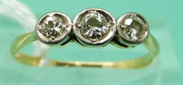 An 18ct gold ring set with three diamonds (largest approx 0.