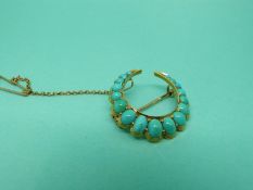 A Victorian brooch in the form of a crescent set with graduated turquoise cabochons