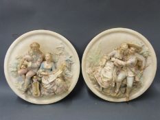 A pair of ceramic relief figural plaques
