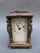 Brass carriage clock of small proportions, the columns decorated with semi-clad female forms,