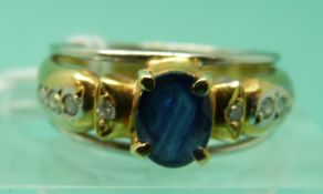 A yellow metal bi-coloured ring set with an oval sapphire and diamonds (size L)