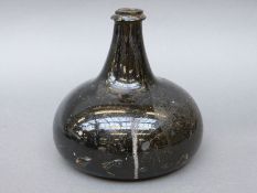 An 18thC green glass wine bottle of squat form,