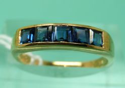 A 14ct gold ring set with 5 square step cut sapphires (size M/N)