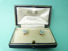 Two 18ct gold and platinum studs each set with mother of pearl and a diamond with engine turned