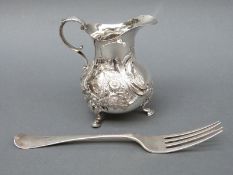 A Victorian hallmarked silver cream jug raised on three feet, London 1874, maker's mark EE FE,