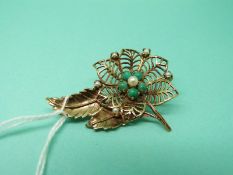 A 9ct gold brooch in a floral design set with turquoise and pearl,