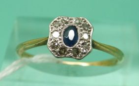 An 18ct gold ring set with an oval sapphire surrounded by diamonds in a platinum setting (size N),