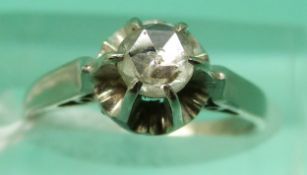 A white metal ring set with a point/rose cut diamond measuring approximately 0.