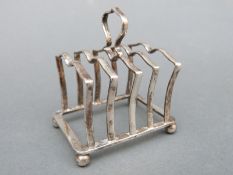 A George VI hallmarked silver four-slice toast rack, Sheffield 1940, maker Adie Brothers Ltd.