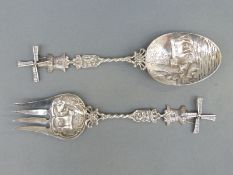 A pair of Dutch white metal fork and spoon salad servers, with embossed bowls and windmill finials,