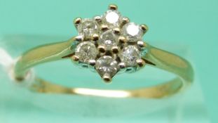 A 9ct gold ring set with seven round cut diamonds in a cluster, total diamond weight 0.